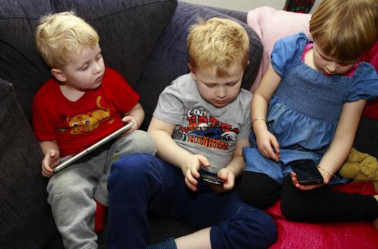 Les enfants jouent avec les smartphones à six mois